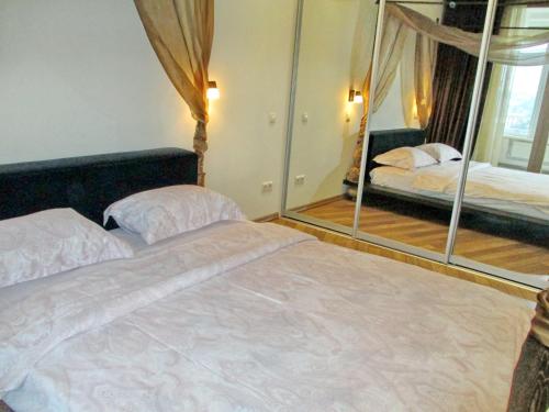 a bedroom with a large bed and a mirror at Most City Apart-Hotel in Dnipro