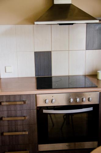 a kitchen with a stove and a microwave at Posti 19 Apartment in Haapsalu
