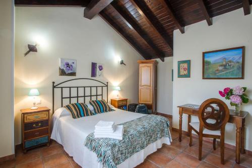 een slaapkamer met een bed, een tafel en een bureau bij Posada Las Tres Mentiras de Santillana del Mar in Santillana del Mar