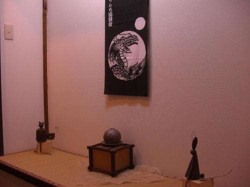 a table with a tv and a picture on the wall at Yufuin Country Road Youth Hostel in Yufuin