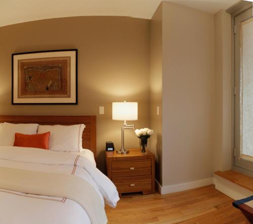 1 dormitorio con 1 cama y 1 mesa con lámpara en Sanctuary NYC Retreats, en Nueva York