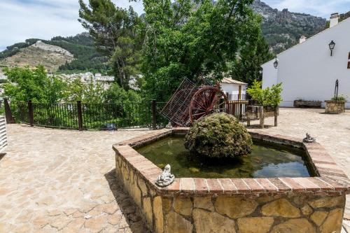 a pool of water with two pigeons in a courtyard with a playground at Villa Turística de Cazorla in Cazorla