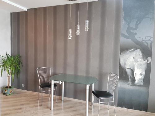 a dining room with a table and a picture of a rhino at Most City Apart-Hotel in Dnipro