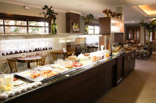 a buffet line with food on display in a restaurant at Hotel Aconchego da Serra in Gramado