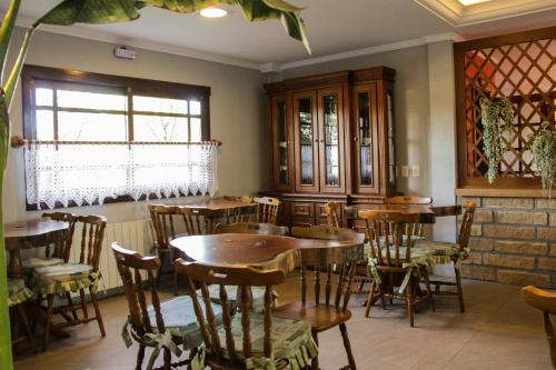 a restaurant with wooden tables and chairs in a room at Hotel Aconchego da Serra in Gramado