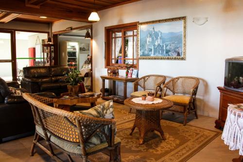 a living room with wicker chairs and tables at Hotel Aconchego da Serra in Gramado