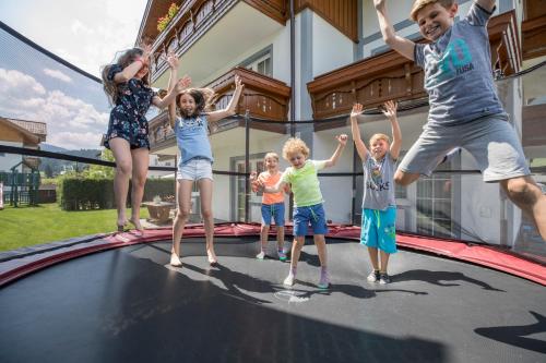 a group of children jumping on a trampoline at Aparthotel Pichler in Flachau
