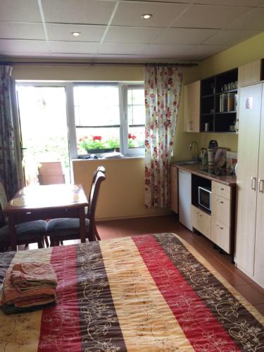a kitchen and dining room with a table and a bed at Lana House in Pärnu