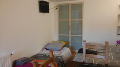 une petite chambre avec un lit et une télévision dans l'établissement Les Bouvines, au Mans