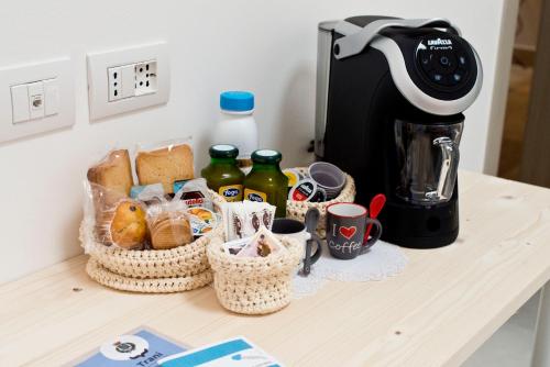 a table with baskets of bread and a coffee maker at TornaRé in Trani