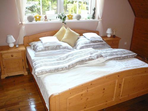 a large wooden bed in a room with a window at Chalupa na Kopečku in Krásná Lípa