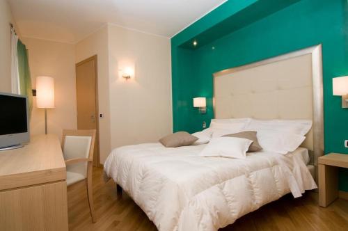a bedroom with a large bed with a green wall at Hotel Europa in Padova