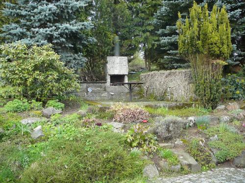 a garden with a stone fireplace in the middle at Chalupa na Kopečku in Krásná Lípa