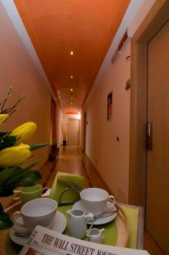a table with cups and plates on it with flowers at Hotel Europa in Padova