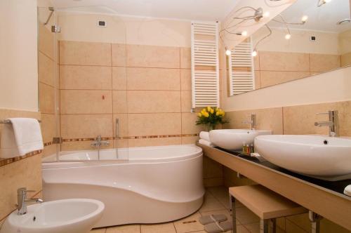 a bathroom with two sinks and a bath tub at Hotel Europa in Padova