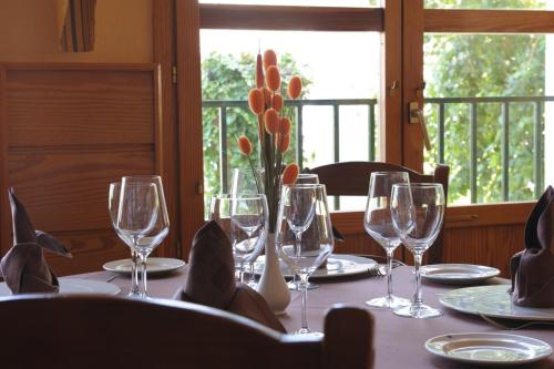 a table with wine glasses and a vase with a plant at Villa Turística de Cazorla in Cazorla