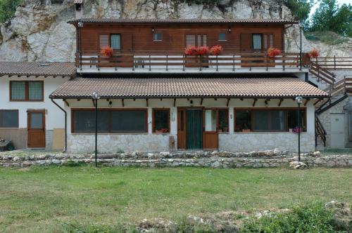 a house with a balcony on top of it at Agriturismo Miralago in Scanno