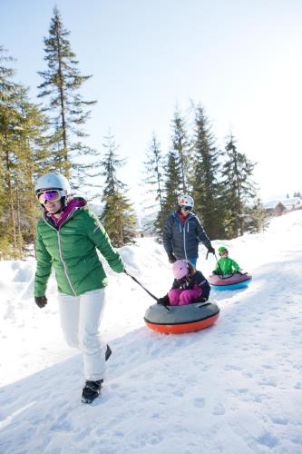 two people are being pulled on snowboards in the snow at Gästehaus Kristall in Kleinarl
