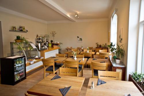 une salle à manger avec des tables et des chaises en bois dans l'établissement Kågeröds Värdshus Tre Stjärnor, à Kågeröd