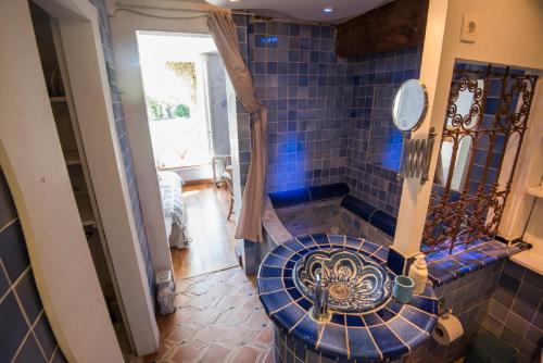 a bathroom with a blue tiled toilet in a room at Domaine à Marmande in Berdoues