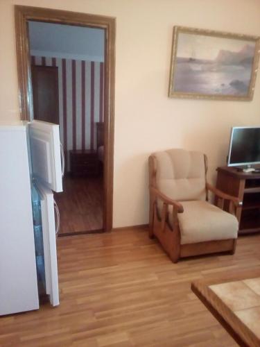 a living room with a chair and a television at Guest House Rusalka in K'obulet'i