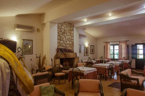 a restaurant with tables and chairs and a fireplace at Sa Pedrera Country Hotel in Càbras