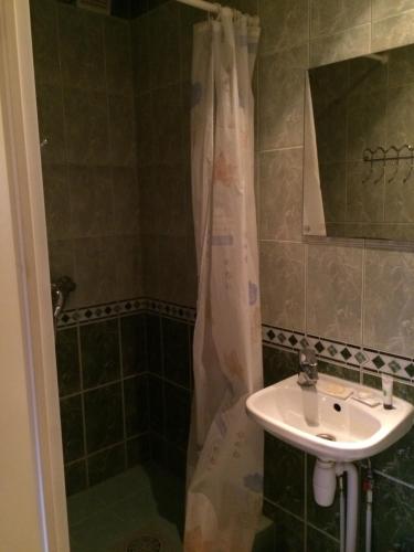 a bathroom with a shower curtain and a sink at Lana House in Pärnu