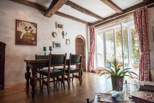 Un comedor con mesa y sillas y una ventana. en Domaine à Marmande, en Berdoues