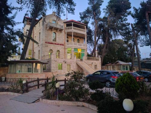 a building with a car parked in front of it at Alhambra Palace Hotel Suites - Ramallah in Ramallah