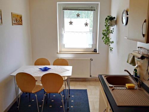 a kitchen with a table and chairs and a window at Ferienwohnung Am Ueckerpark in Ueckermünde