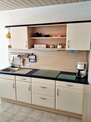 a kitchen with white cabinets and a sink at Ferienwohnung Am Ueckerpark in Ueckermünde