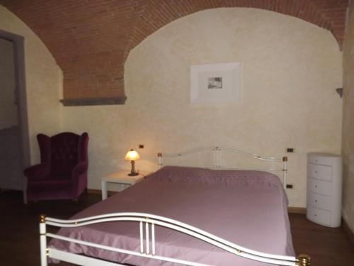 a bedroom with a bed and a chair at Il Poggiale in Empoli