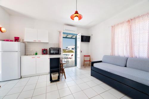 a living room with a couch and a kitchen at Fivos Apartments in Aliki