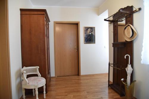 a hallway with a chair and a wooden door at Schlafen in Weimar in Weimar