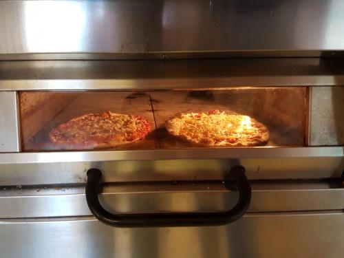 two pizzas are cooking in an oven at Eckerö Camping & Stugor in Eckerö