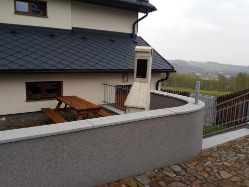 a balcony of a house with a bench and a table at Haus Tolštejn in Jiřetín pod Jedlovou