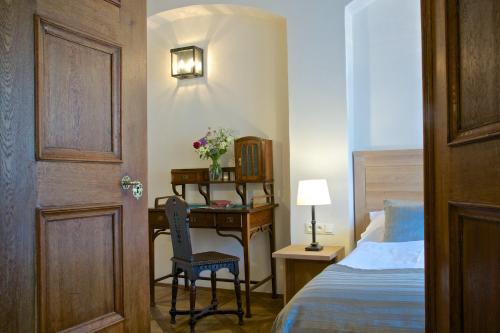 a bedroom with a desk with a bed and a chair at Residence U Mecenáše in Prague