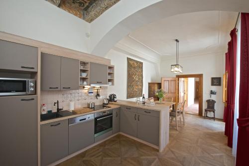 a kitchen with white cabinets and a dining room at Residence U Mecenáše in Prague