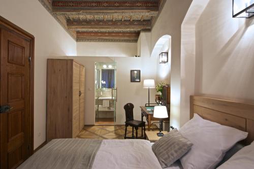 a bedroom with a bed and a desk in a room at Residence U Mecenáše in Prague