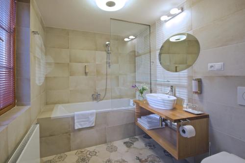 a bathroom with a tub and a sink and a bath tubermott at Residence U Mecenáše in Prague