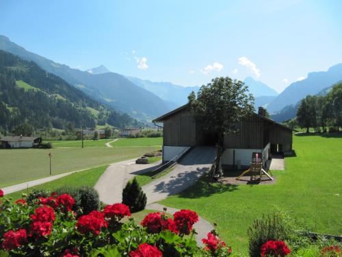 a small building in a field with red flowers at Huaterhof in Zell am Ziller