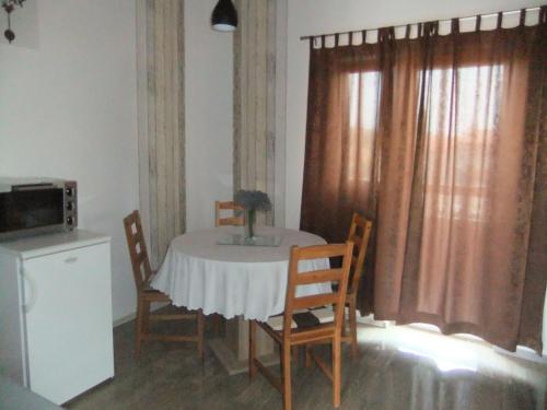 a dining room table with chairs and a microwave at Apartments Ivanković in Stari Grad