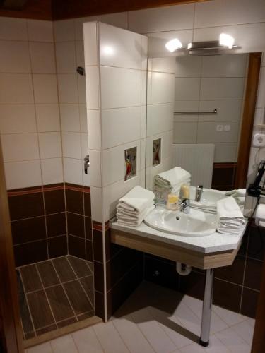 a bathroom with a sink and a mirror at Zöld sziget Apartmanház in Gyenesdiás