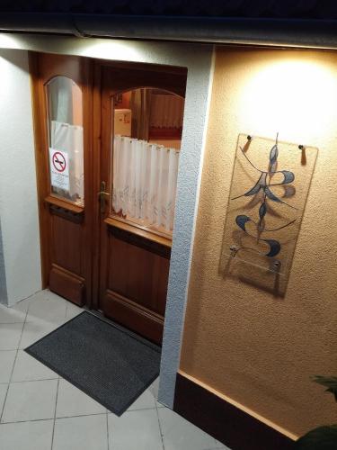 a room with a door with a light on the wall at Zöld sziget Apartmanház in Gyenesdiás