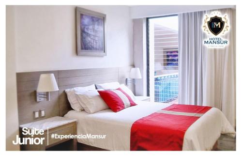a bedroom with a bed with a red blanket and a window at Hotel Mansur Business & Leisure in Córdoba