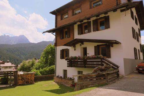 a house with a balcony with flowers on it at Appartamento Piller Roner Paola in Sappada