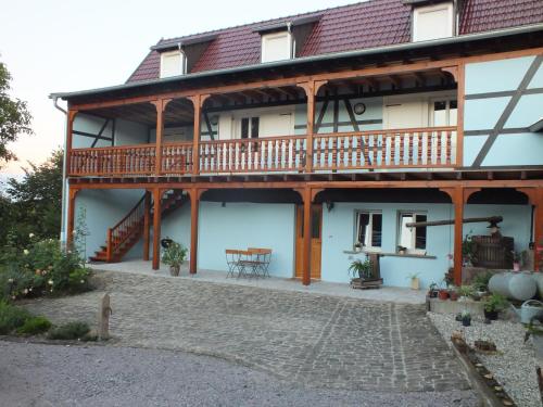 a large house with a balcony and a patio at Gîte Découverte Alsace in Kuhlendorf