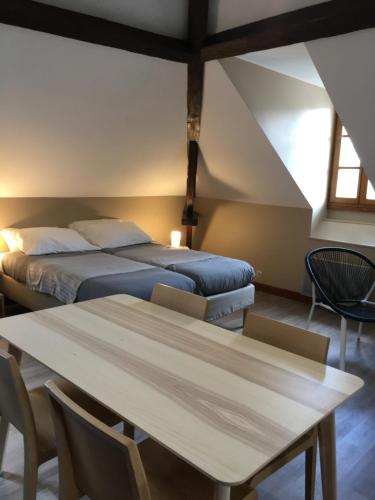 a bedroom with a bed and a table and chairs at La Villa Esponda in Saint-Jean-Pied-de-Port