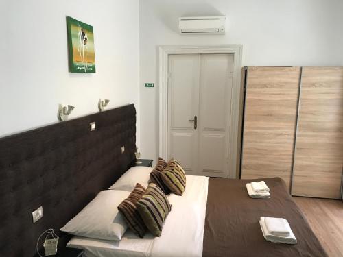 a bedroom with a large bed with two pillows at Pula Antic Rooms in Center in Pula