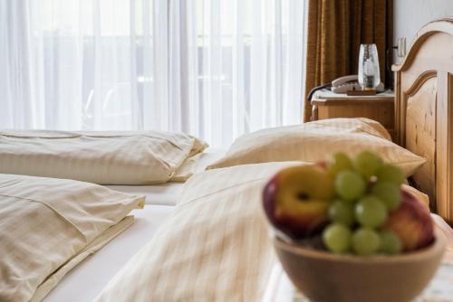 a bowl of fruit sitting on top of a bed at Pension Bäuerle in Heiligenblut